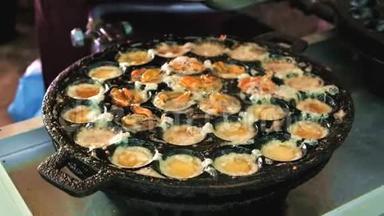 泰国的街头美食.. 在Kanom Krok铁锅里用贻贝煮鸡蛋。